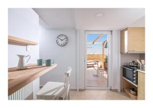 a kitchen with a table and a clock on the wall at Baulus Yard Luxury I in Heraklio Town +12 photos