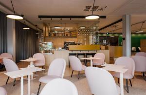 a restaurant with white chairs and tables and a counter at The Lab Hotel & Apartments in Thun