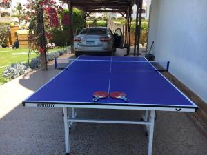 una mesa de ping pong azul con gafas de sol. en Luxury Villa Panorama Beach en El Alamein