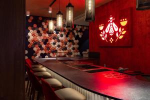 eine Bar mit roter Beleuchtung in einem Restaurant in der Unterkunft Maison Mère in Paris