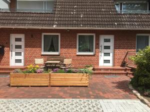 ein Haus mit zwei Holzpflanzen davor in der Unterkunft Ferienwohnung Paradies in Blekendorf