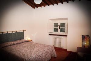 1 dormitorio con cama y ventana en La terrazza del vecchio Mulino, en SantʼAndrea di Compito