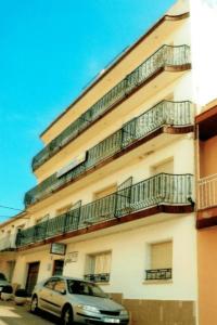 une voiture garée devant un immeuble avec balcon dans l'établissement Camino de Santiago Guesthouse, à Llançà