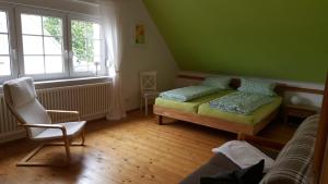 a bedroom with a bed and a chair and window at Hofgestüt Bleesern FEWO2 in Bleesern