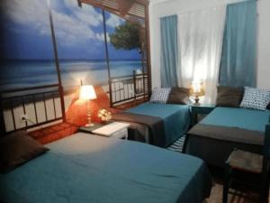 Camino de Santiago Guesthouse في يانسا: غرفة بسريرين وشرفة مطلة على المحيط