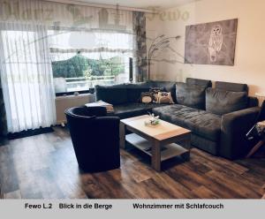 a living room with a couch and a table at Eulennestchen-Harz Fewo S1 oder L2 Für Single, Paar oder Familie & Hund Oberharz in Altenau