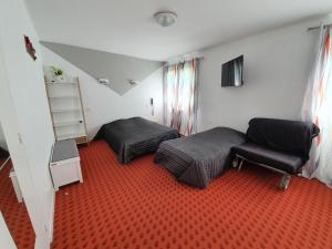 a small bedroom with two beds and a chair at Hotel De La Poste in Espinasses +21 photos