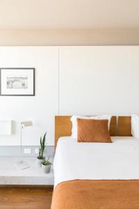 1 dormitorio con 1 cama grande con sábanas blancas en Opta Coliving Punta Carretas, en Montevideo