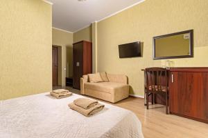 カバルジンカにあるGuest House Aniksiのベッドと椅子付きのホテルルーム