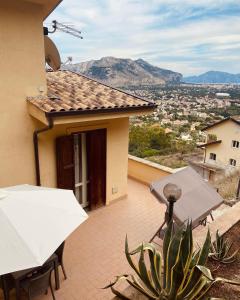 een balkon van een huis met een tafel en een parasol bij L'Oasi dell'Eremita in Mondello