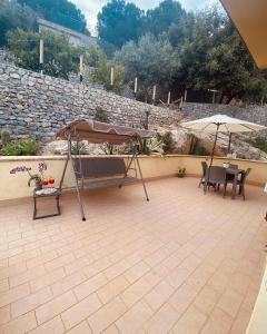 un patio con sombrilla, mesa y sillas en L'Oasi dell'Eremita en Mondello