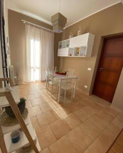 a kitchen and dining room with a table and chairs at L'Oasi dell'Eremita in Mondello