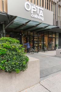 a person walking a bike in front of a building at Opta Coliving Punta Carretas in Montevideo