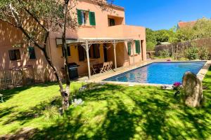 une maison avec une piscine dans une cour dans l'établissement Villa La Giraudière, à Calvi