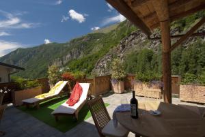 a patio area with chairs, tables, and a balcony at Miramonti in Valtournenche
