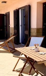 uma mesa de madeira e cadeiras num pátio em Sicilian Seaside Apartments em Augusta