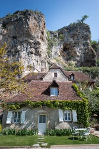 a house in front of a rocky mountain at Logis Hôtels - Hôtel Restaurant Domaine Les Falaises in Martel