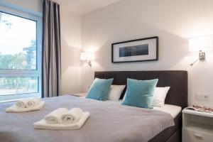 1 dormitorio con toallas en una cama con ventana en Appartement "Diamant" mit Penthouseflair - Oase am Haff, en Garz