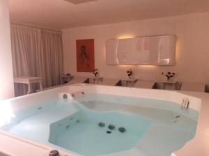 
a bath room with a tub and a chair at Grand Hotel Santa Teresita in Mar del Plata
