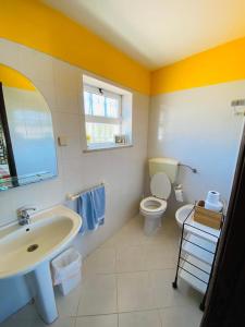 a bathroom with a sink and a toilet at Eucalipto in Faro