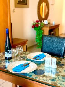 a table with two plates and a bottle of wine at The Blue Apartments in Hersonissos
