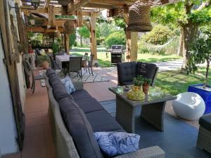 a patio with a couch and a table and chairs at VILLA LES HAUTS VALLONS in Puylaroque