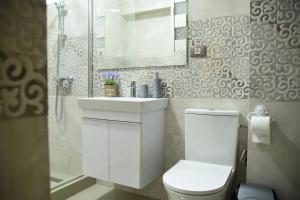 a bathroom with a toilet and a sink and a mirror at Ideal MoonLight Residence in Mamaia +5 photos