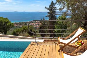 a chair sitting on a deck next to a swimming pool at Greenstone Villas Corfu - Luxury Sea View Villas in Pyrgi
