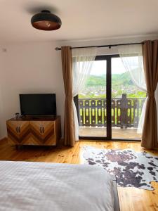 a bedroom with a bed and a large window at PANORAMIC Sus In Deal in Vişeu de Jos