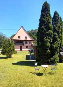 a house with chairs and a table in the grass at Ferienwohnung Tremmbach in Salzwoog
