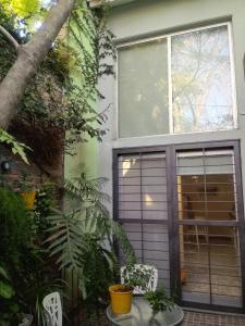 uma casa com uma porta de garagem e algumas plantas em Jardin Secreto em Rosário