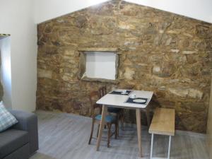 Habitación con mesa y pared de piedra. en Casa Hozani, en Albarrol