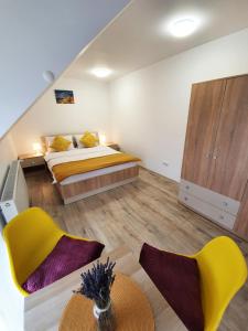 1 dormitorio con 1 cama, 2 sillas y mesa en Lavender Apartments en Sînpetru