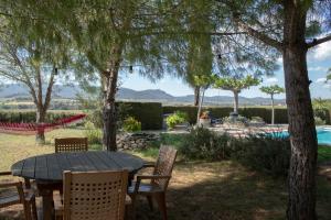 una mesa y sillas en un patio con piscina en Romegosa Benestar, en Sant Marçal
