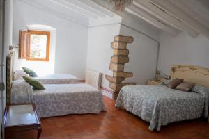 a bedroom with two beds and a stone pillar at Romegosa Benestar in Sant Marçal +52 photos