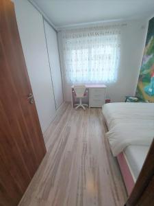 une chambre avec un lit, un bureau et une fenêtre dans l'établissement Paula Apartment, à Uisenteş 4 autres photos