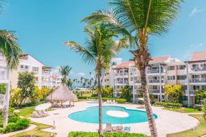 vista para a piscina do resort com palmeiras em Playa Turquesa Ocean Club em Punta Cana