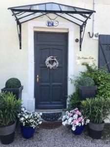 une porte noire avec des plantes en pot devant une maison dans l'établissement LA MAISON D INÈS and UGOLIN & Spa, à Baccarat