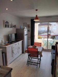 a kitchen with a table and a kitchen with a refrigerator at Charmant studio Bord de mer Plage Ste Marguerite Pornichet in Pornichet