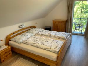 una camera da letto con un letto di legno e una finestra di Ferienwohnungen Rasinger a Schiefling am Wörthersee