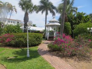 a gazebo in a park with palm trees and flowers at Lemon Tree Inn in Naples