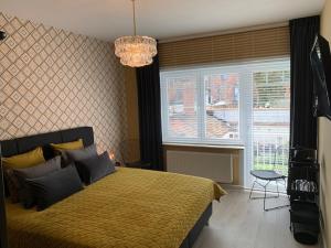 a bedroom with a large bed and a window at BnB De Koepoort in Mechelen