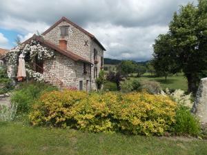an old stone house with flowers in the yard at côté jardin in Saint-Clément