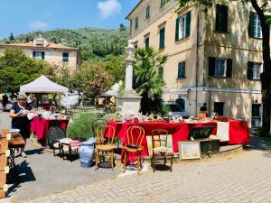 a table with red tables and chairs in front of a building at BB Palazzo Doria in Dolcedo