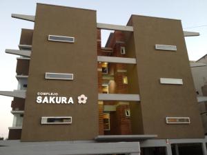 een gebouw met een bord aan de zijkant bij Complejo Sakura in Villa Gesell