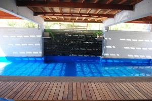 a swimming pool with blue water and a wooden deck at Complejo Sakura in Villa Gesell