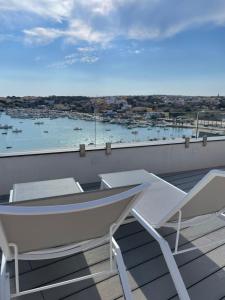a balcony with two chairs and a view of a harbor at B&B Giro Di Boa in Lampedusa
