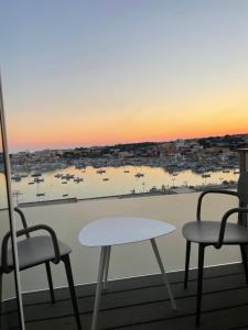 a table and chairs on a balcony with a view of a harbor at B&B Giro Di Boa in Lampedusa