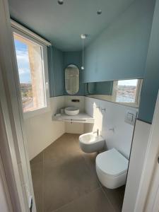 a bathroom with a toilet and a sink and a mirror at B&B Giro Di Boa in Lampedusa