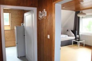 ein Zimmer mit Kühlschrank und ein Schlafzimmer mit Bett in der Unterkunft Ferienwohnung Monteurwohnung Rose 15 Isenbüttel in Isenbüttel